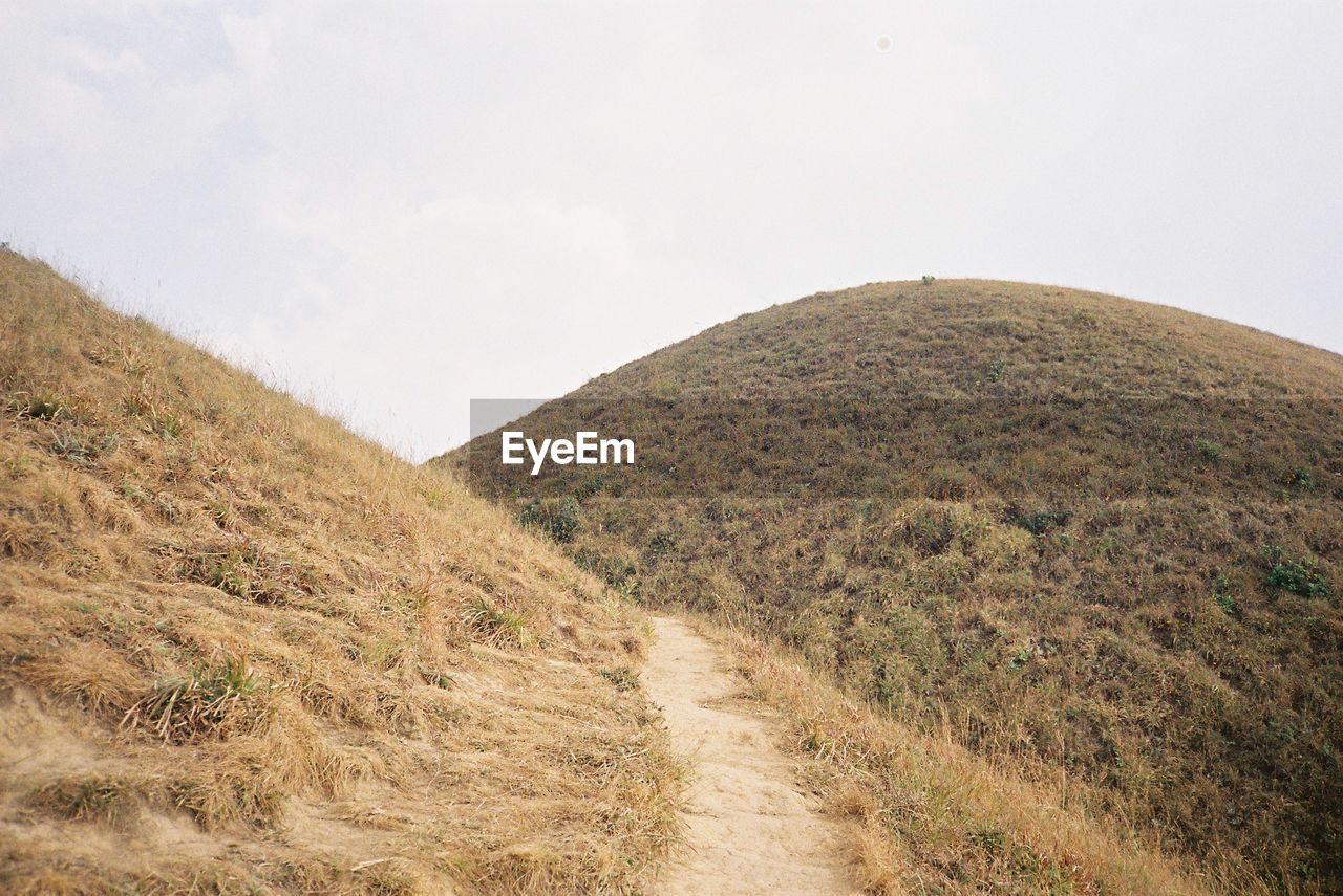 SCENIC VIEW OF ROAD AMIDST MOUNTAINS AGAINST SKY