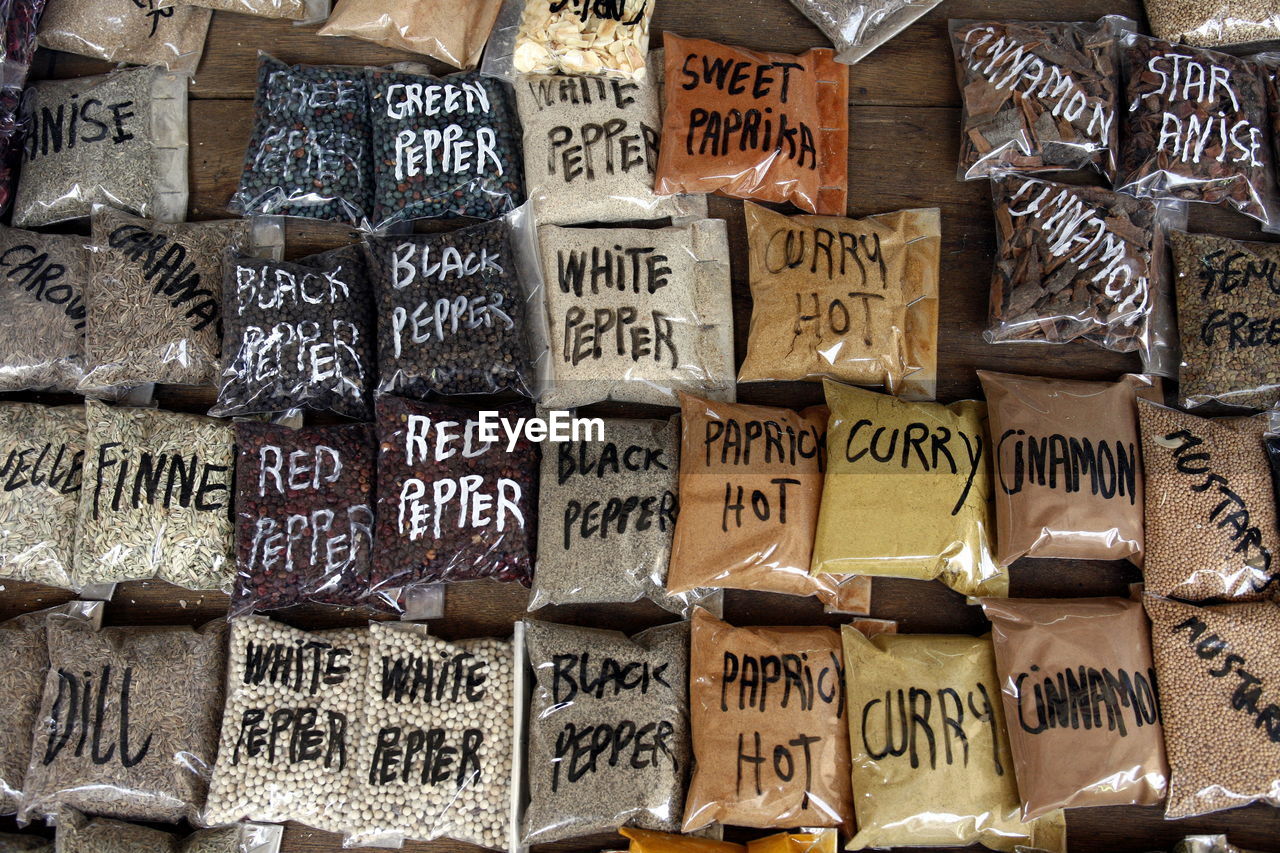 High angle view of grounded spices packets arranged on table for sale