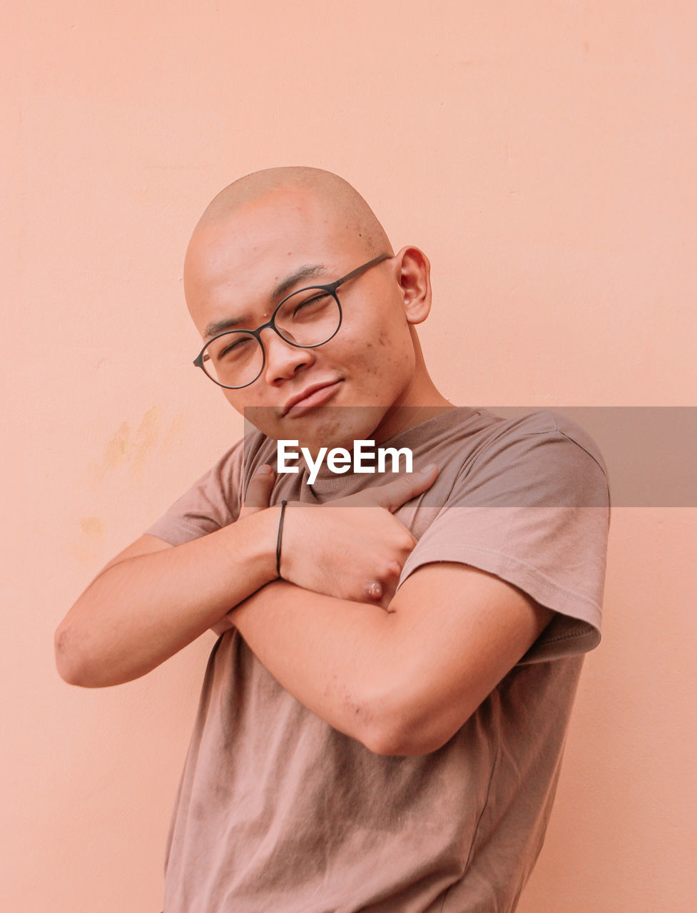 Portrait of young man standing against wall