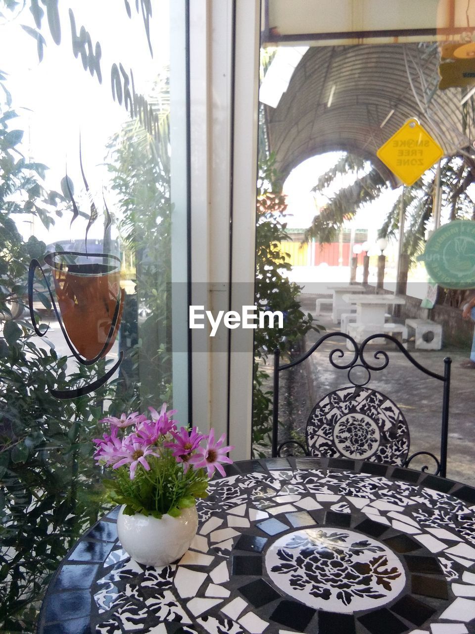 FLOWER VASE ON TABLE AGAINST WINDOW