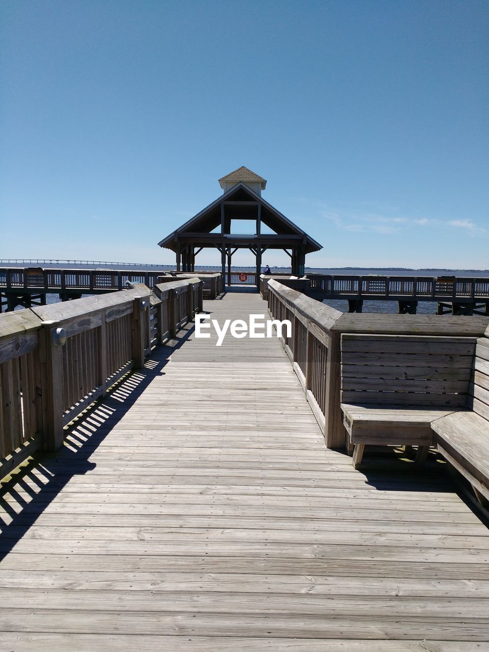 WOODEN FOOTBRIDGE ON PIER AGAINST CLEAR SKY