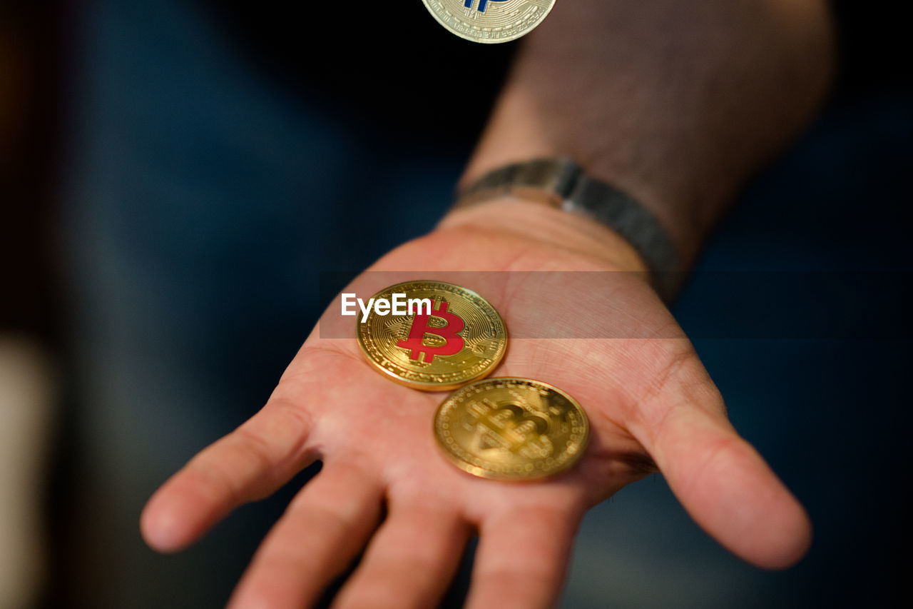 Close-up of person holding bitcoins