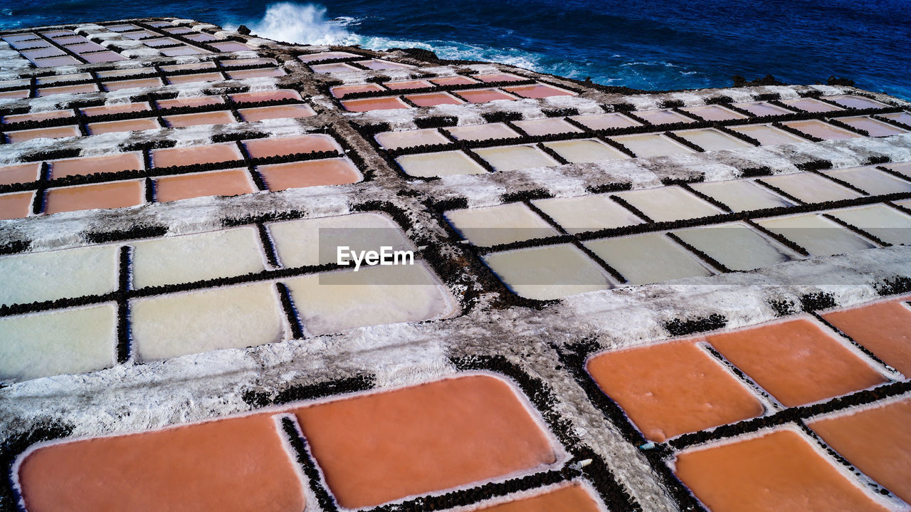 High angle view of salt flat sea salk farm water fields multicolour texture background 