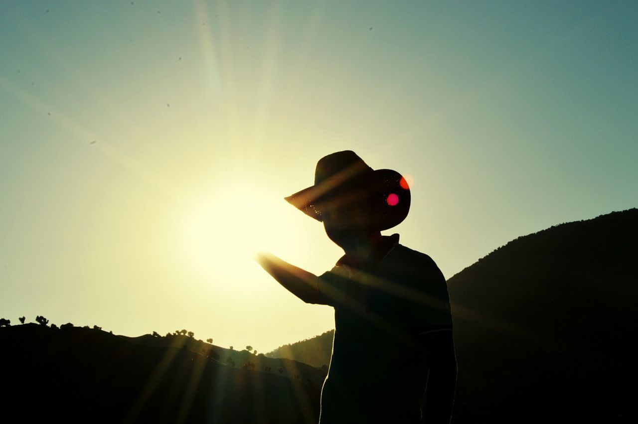 Silhouette man standing against sky during sunset