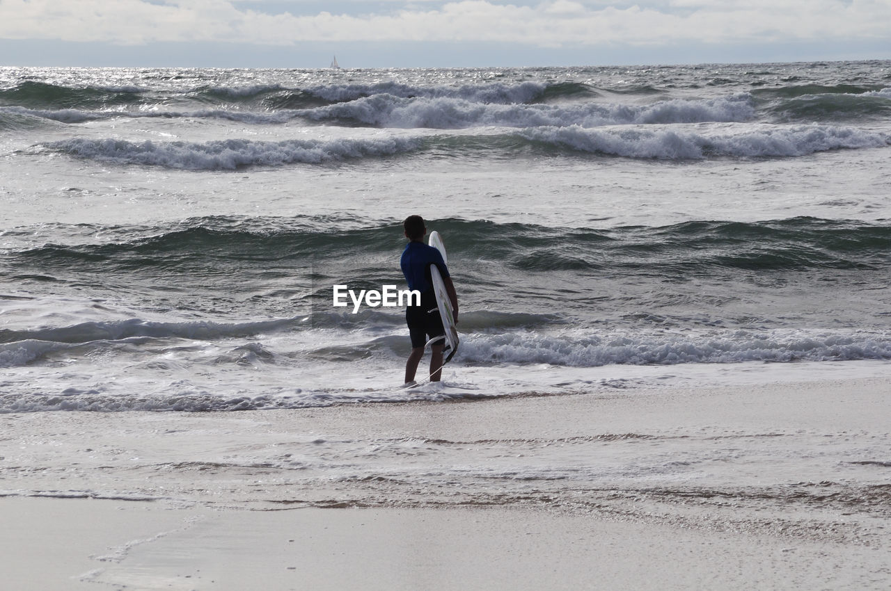 Male surfer with surfboard in sea