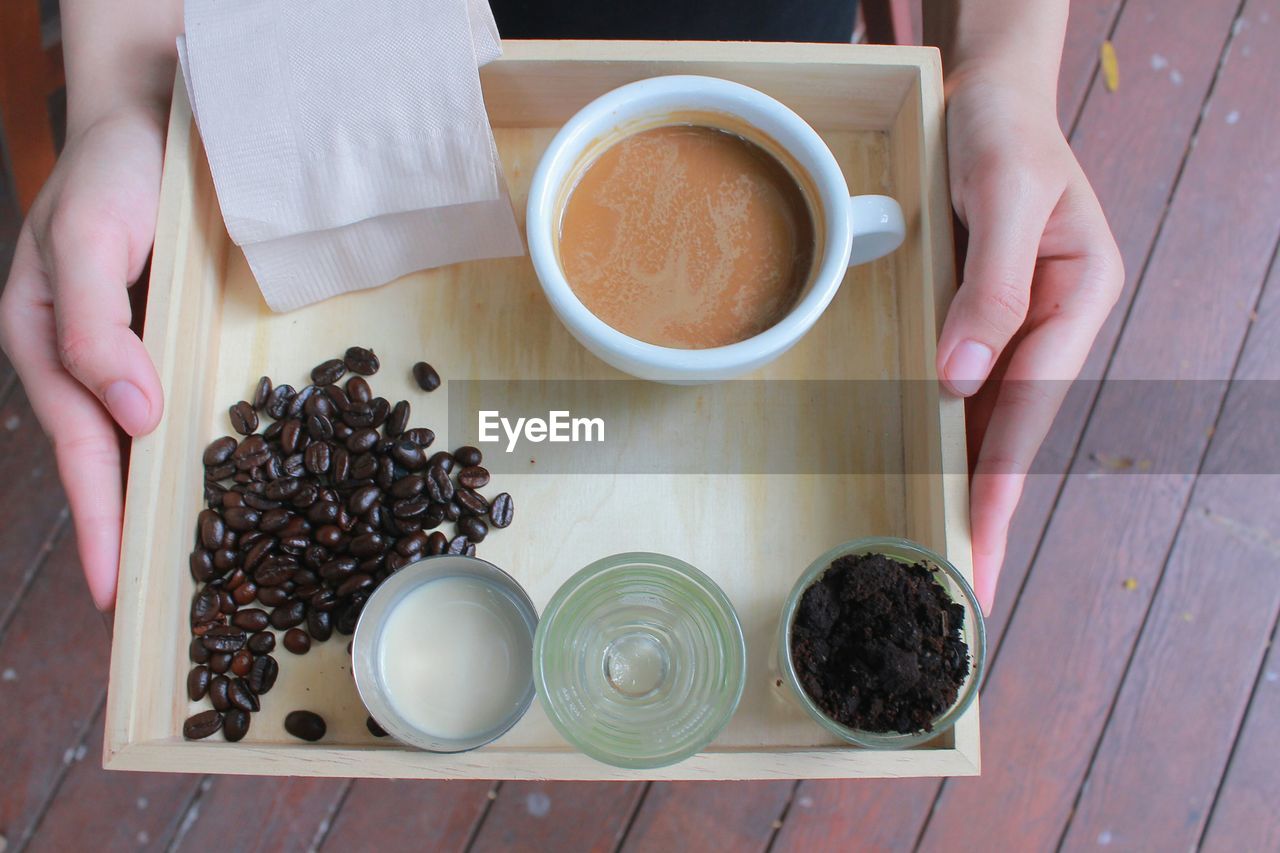 High angle view of coffee cup and beans on tray