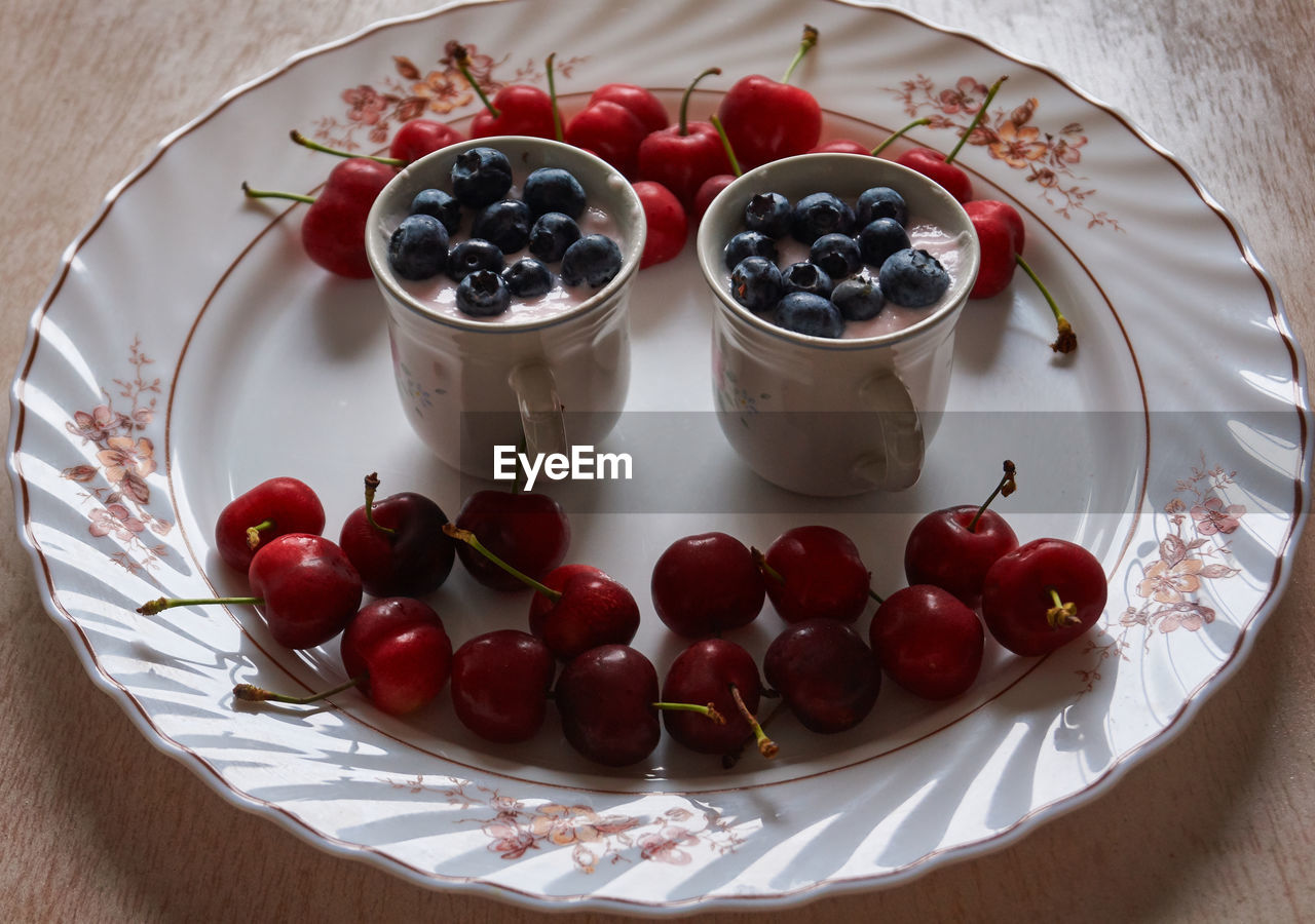 Sweet cherries on a plate with yogurt