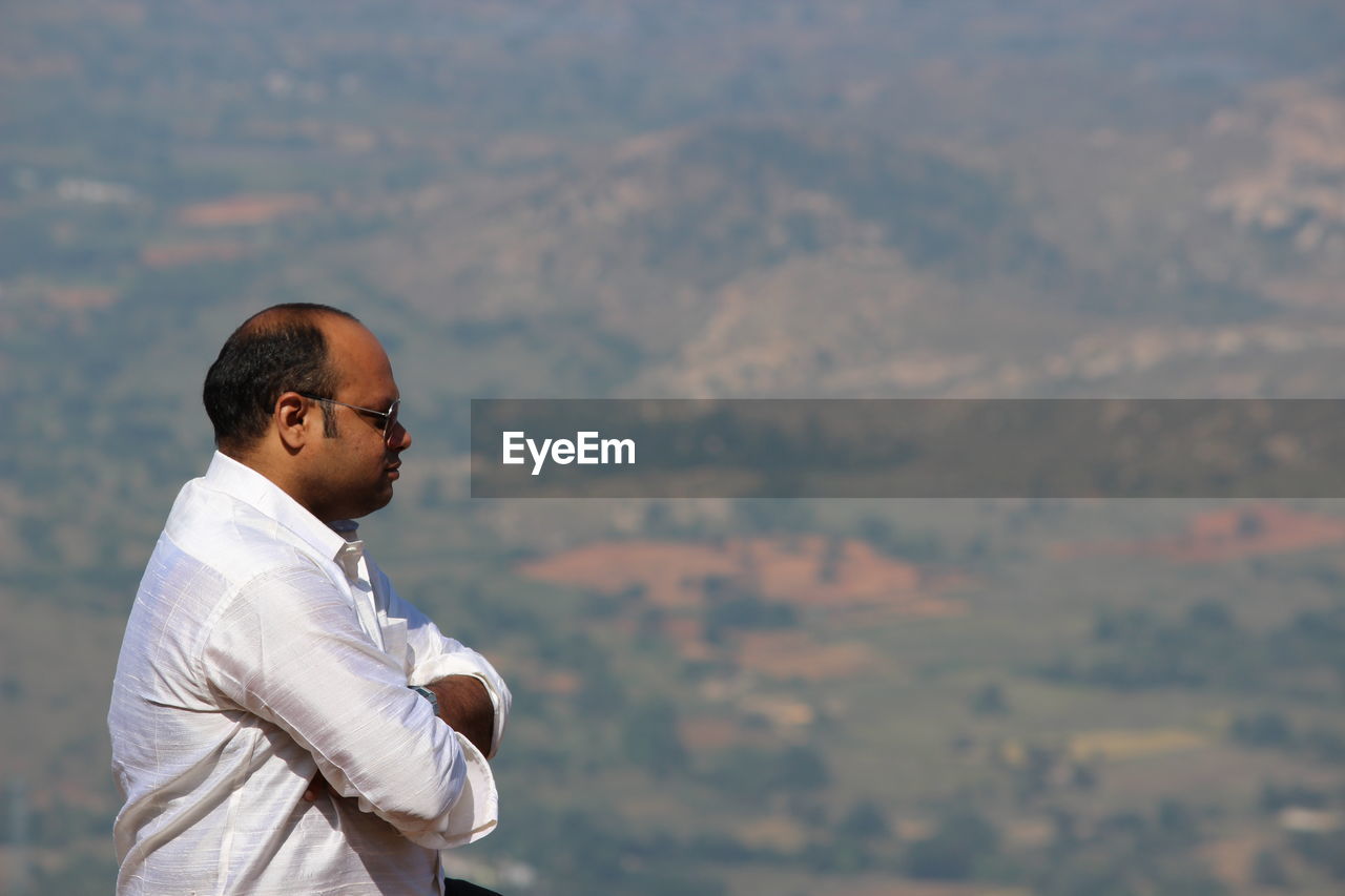 Side view of man wearing sunglasses against landscape 