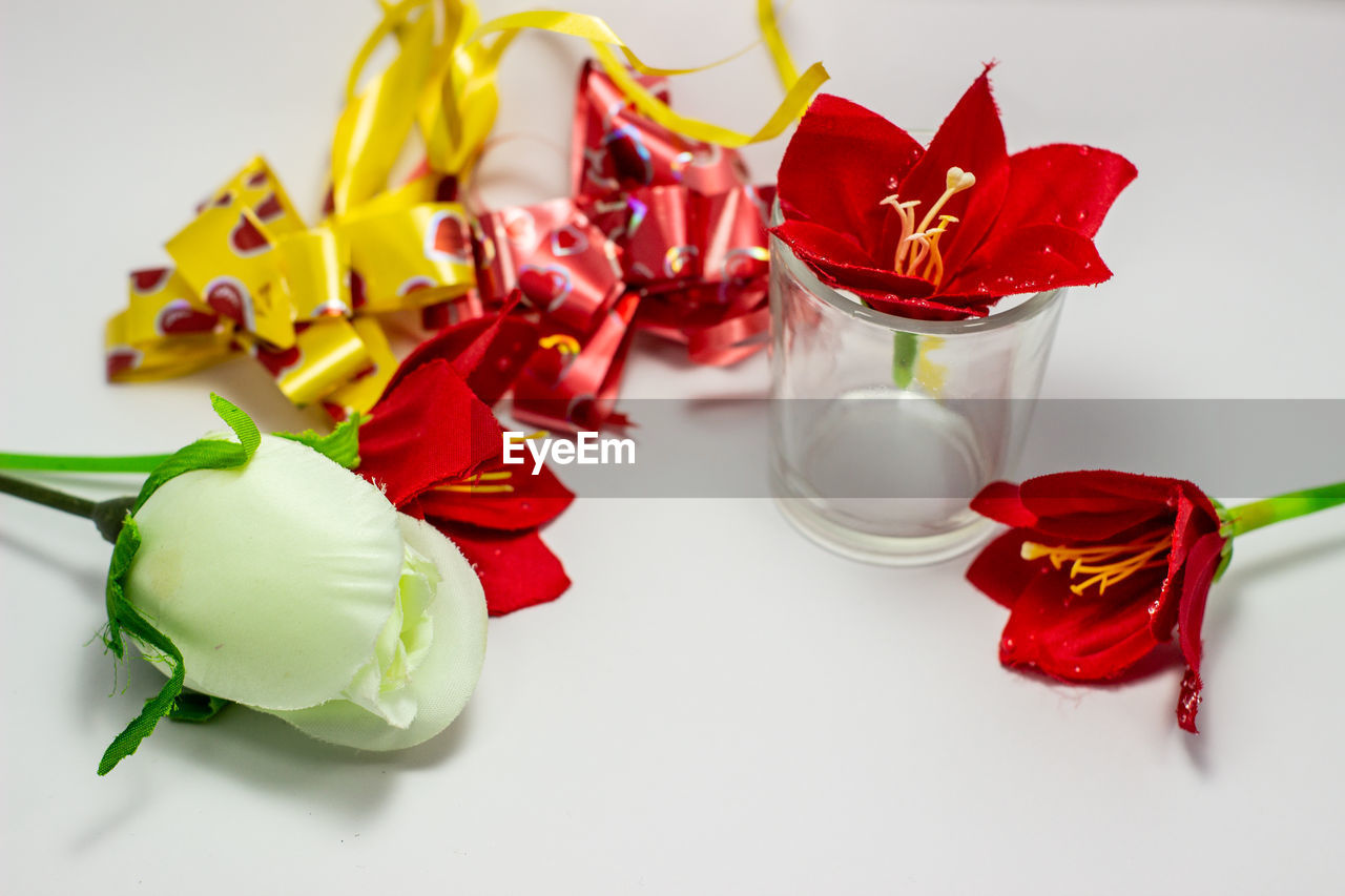 HIGH ANGLE VIEW OF RED ROSES ON WHITE TABLE