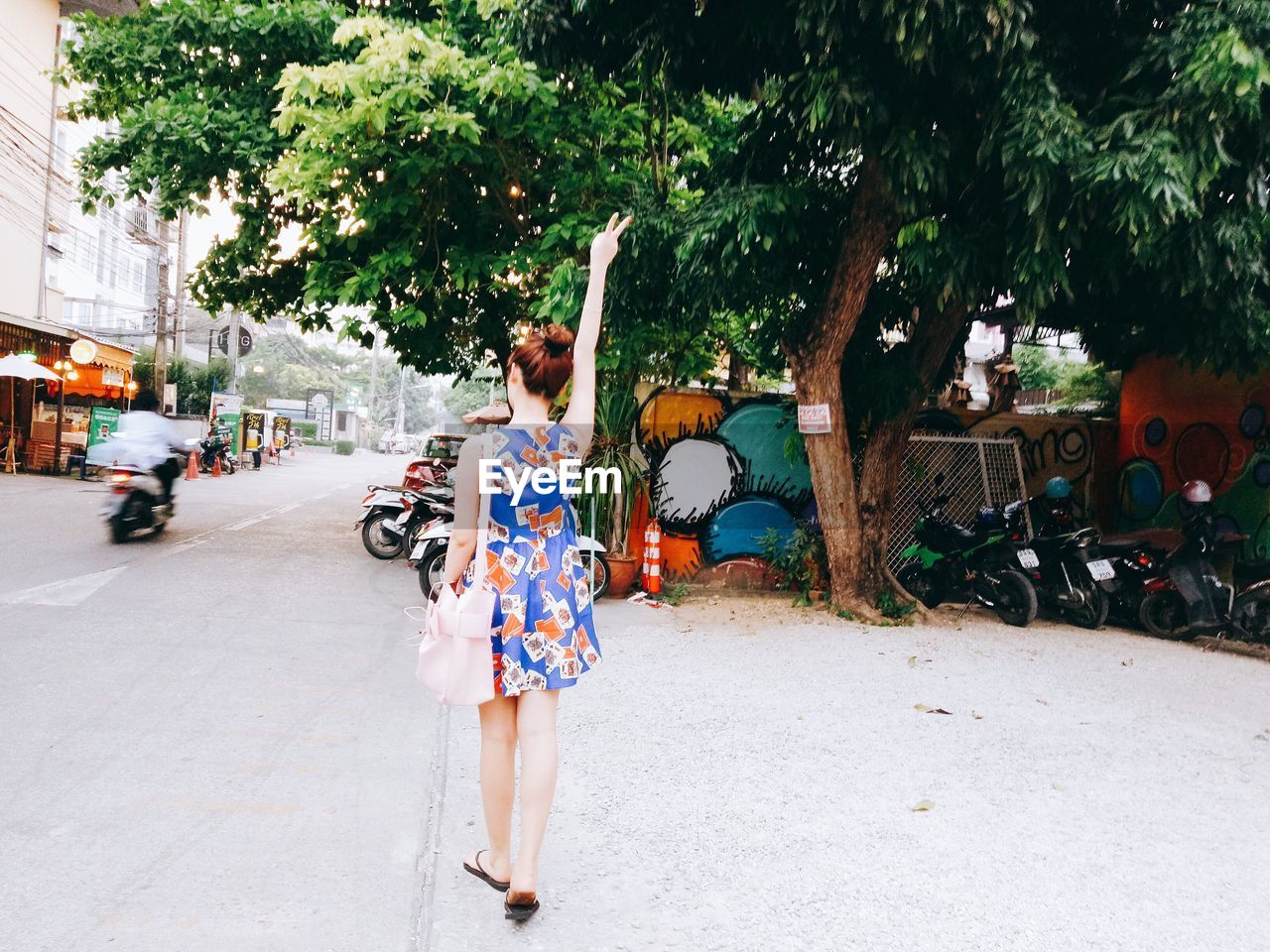 WOMAN STANDING ON TREE TRUNK