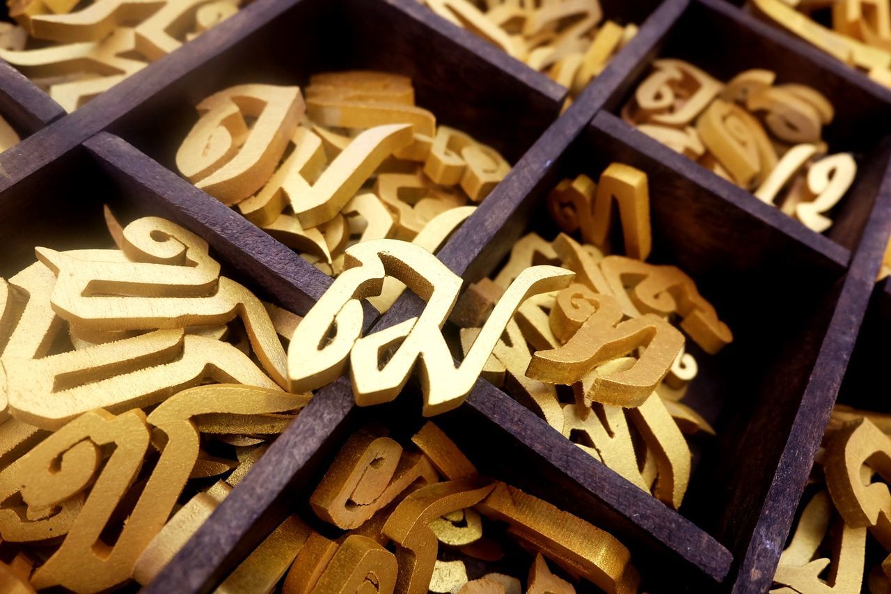 Close-up of various wooden alphabets in containers