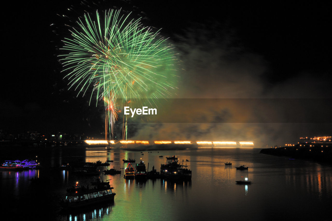 FIREWORK DISPLAY OVER WATER AT NIGHT