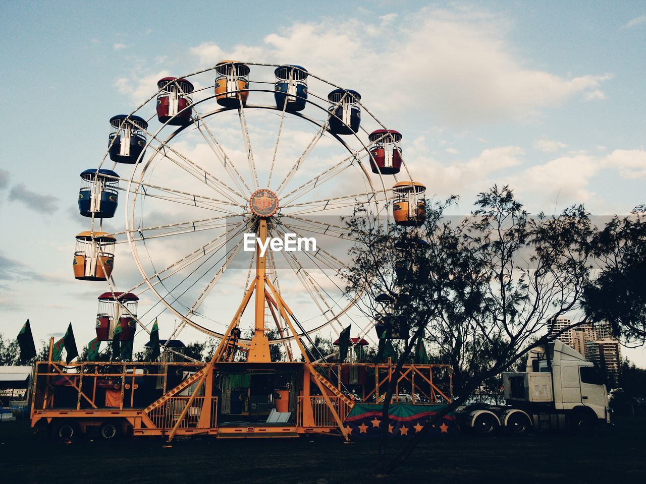 LOW ANGLE VIEW OF FERRIS WHEEL AGAINST SKY AT NIGHT