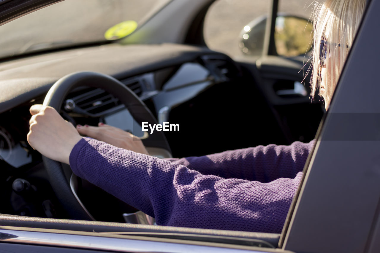cropped hand of woman driving car