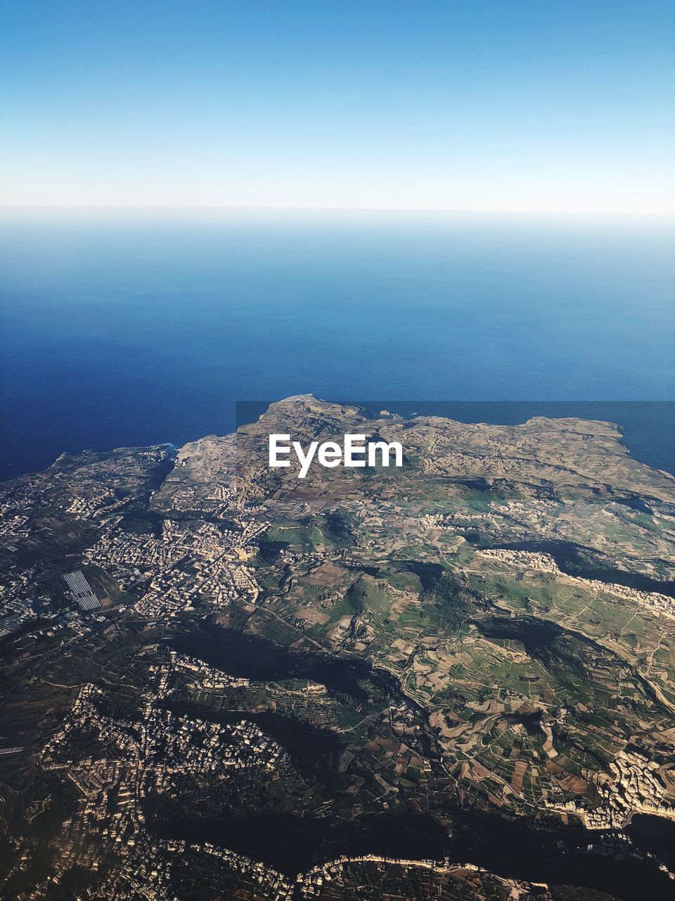 High angle view of sea and land against sky