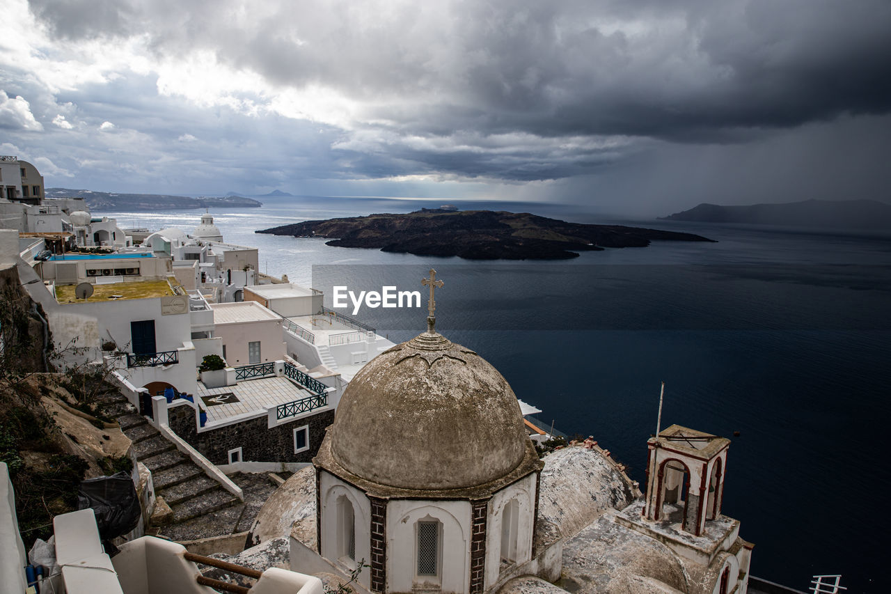Panoramic view of buildings and sea against cloudy sky