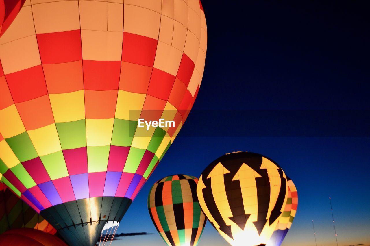 Low angle view of illuminated hot air balloons against clear sky during festival