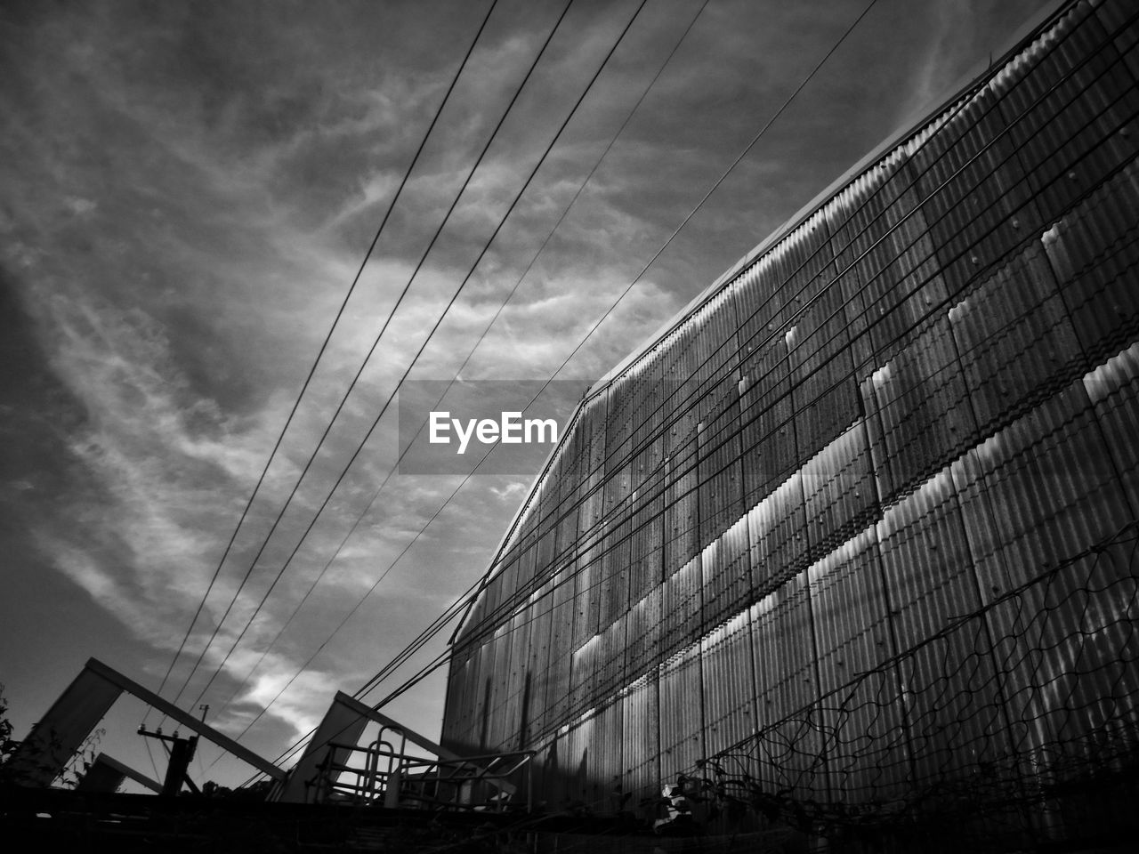 LOW ANGLE VIEW OF MODERN GLASS BUILDING AGAINST SKY