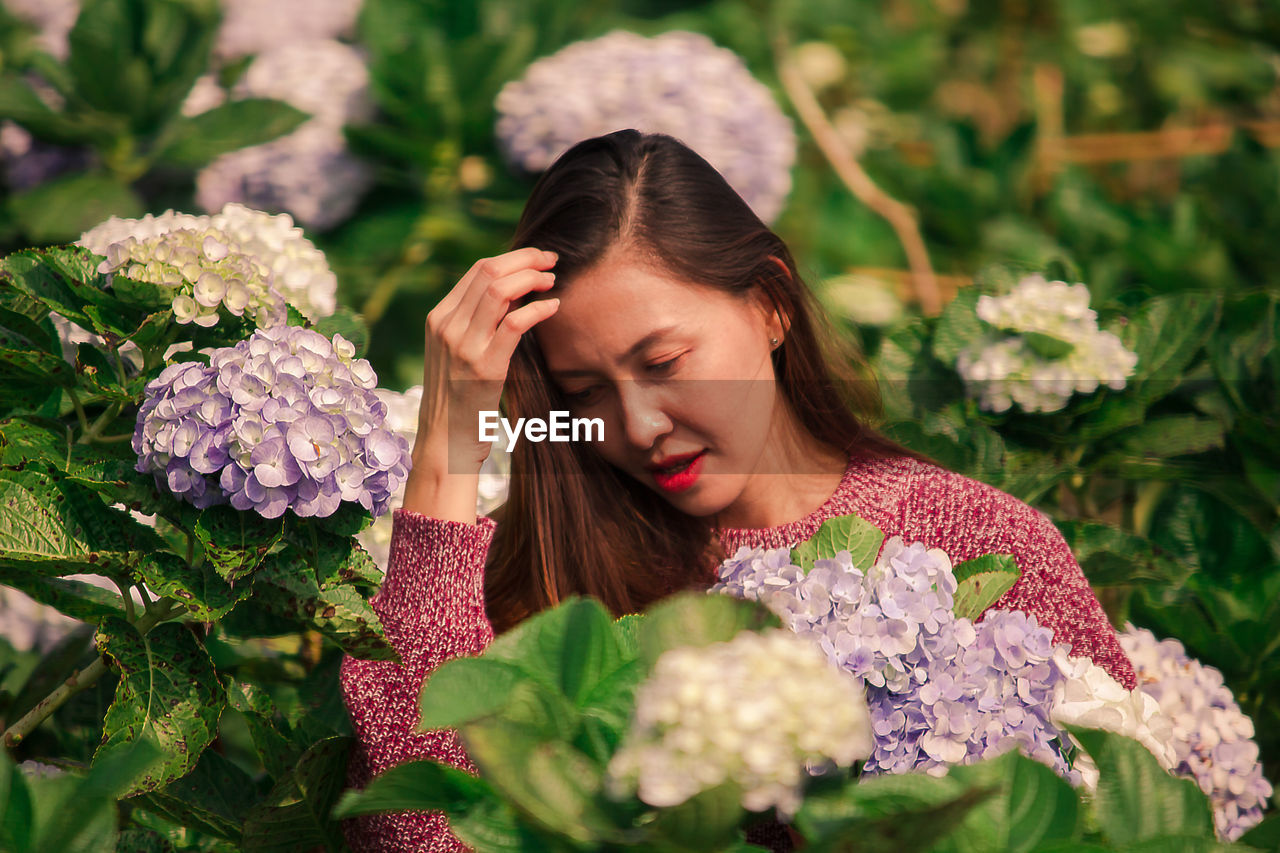 Smiling woman by flowering plants