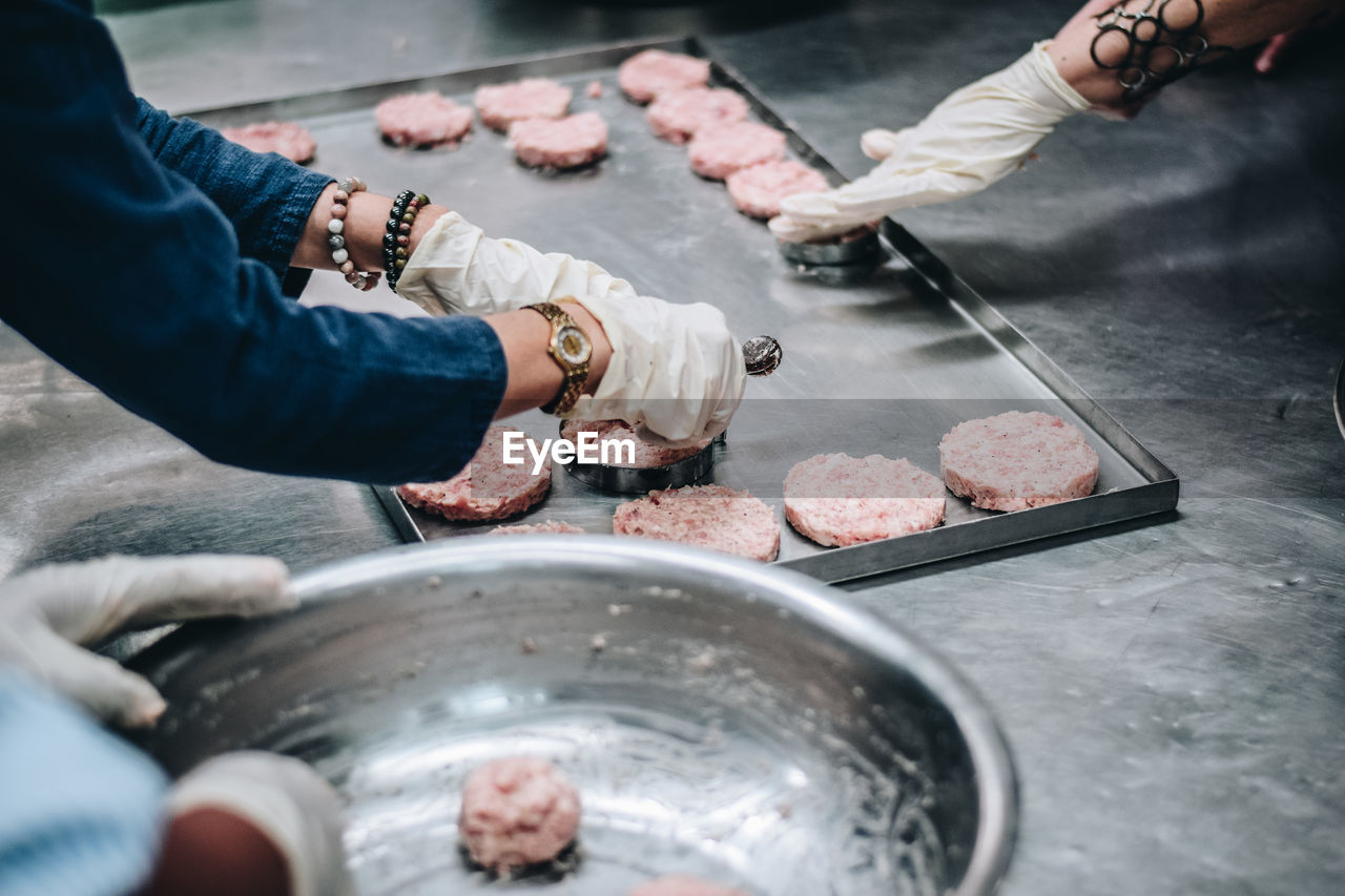 Cropped hands of women preparing food in kitchen