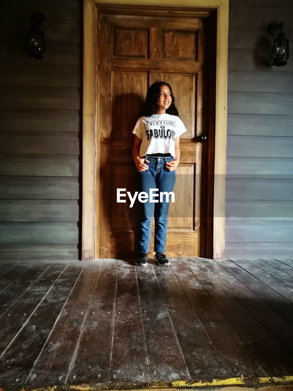 Full length of girl standing against door