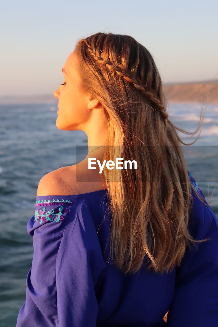 Beautiful woman looking at sea against sky