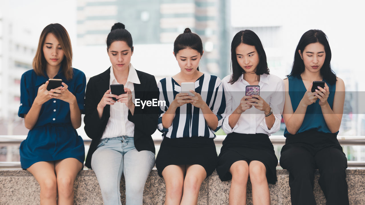 GROUP OF PEOPLE USING PHONE