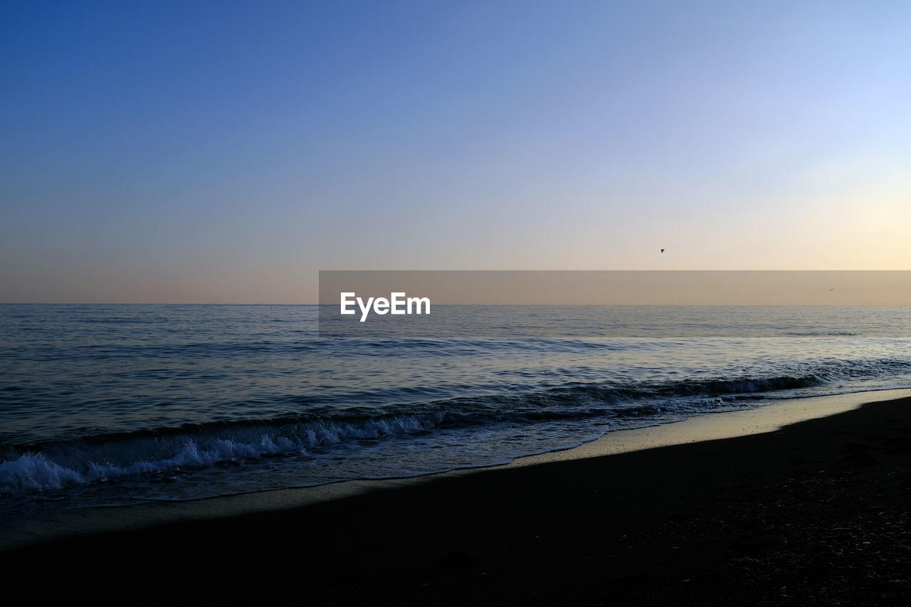 Scenic view of sea against clear sky during sunset