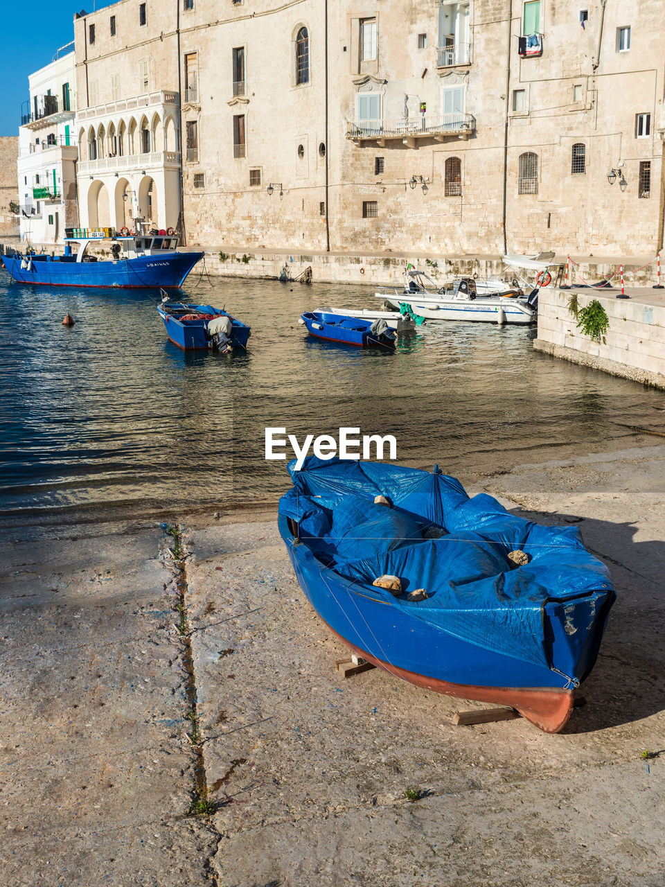 BOATS MOORED ON CANAL AMIDST BUILDINGS IN CITY