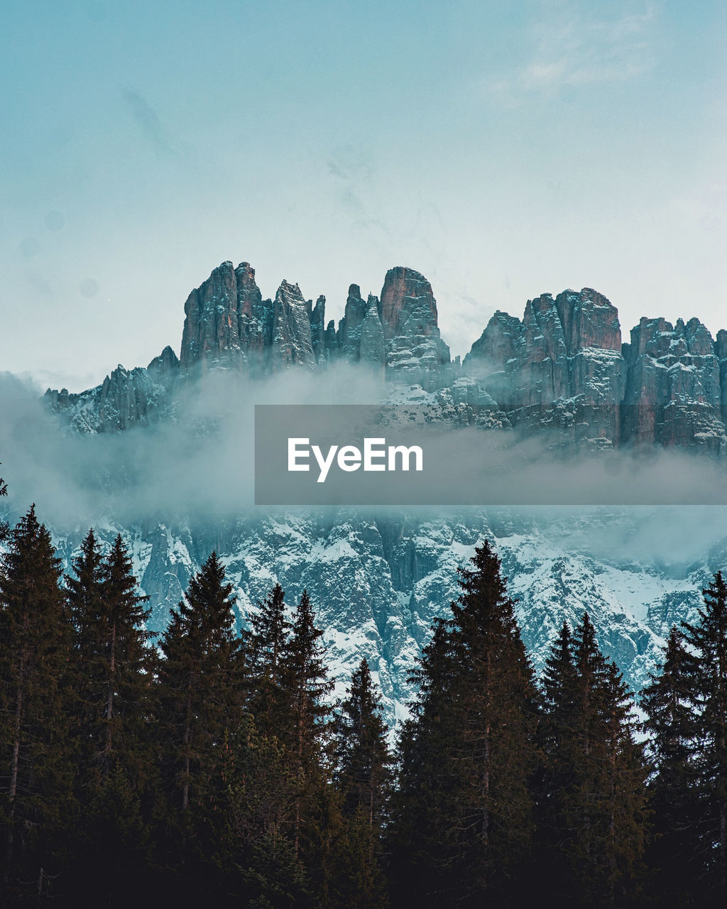 Scenic view of pine trees against dolomites and sky during winter