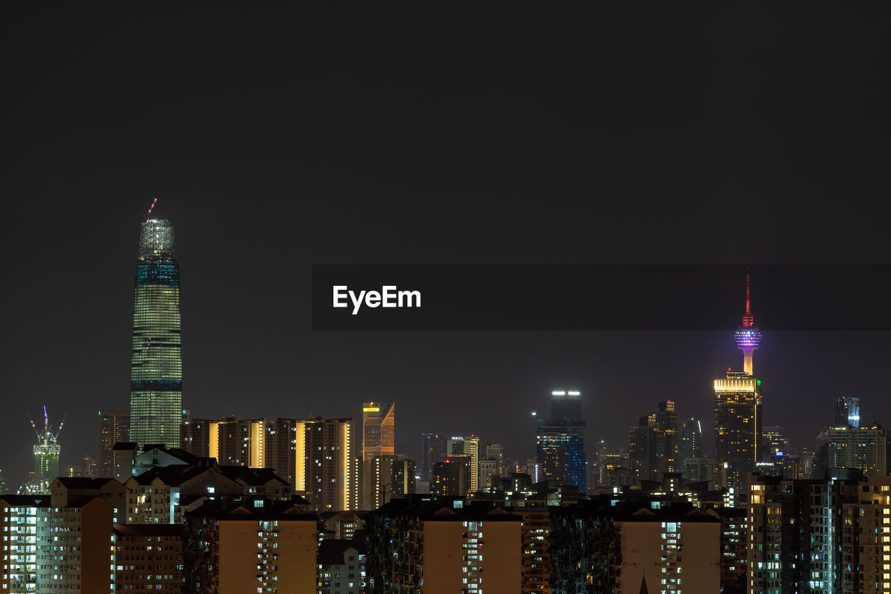 ILLUMINATED MODERN BUILDINGS IN CITY AT NIGHT