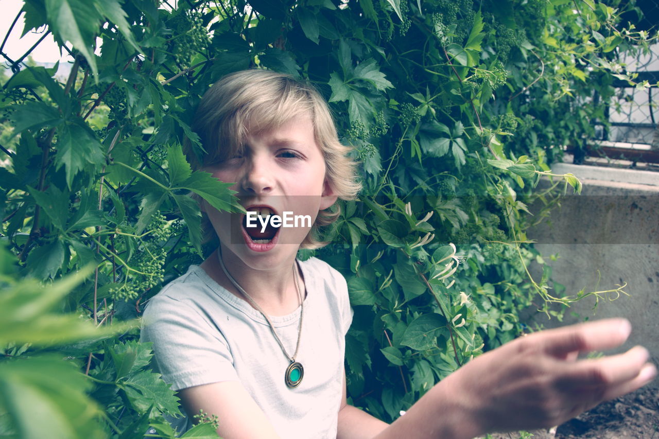 Close-up portrait of boy against plants