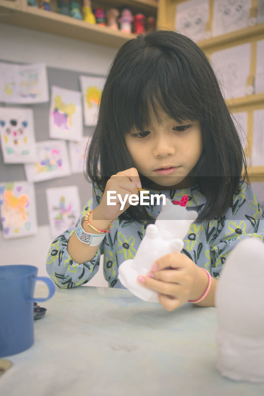 Innocent girl painting toy