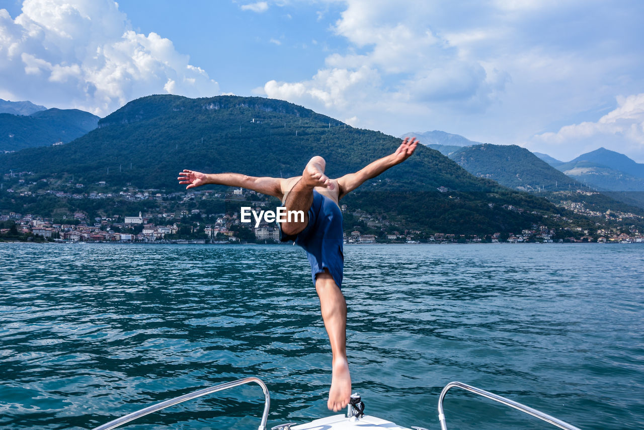 Shirtless man diving into lake