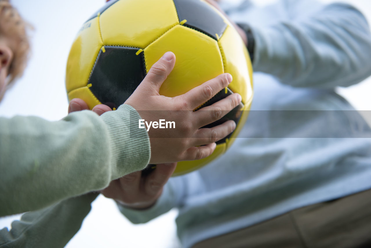 A little boy plays soccer with his father on the soccer field