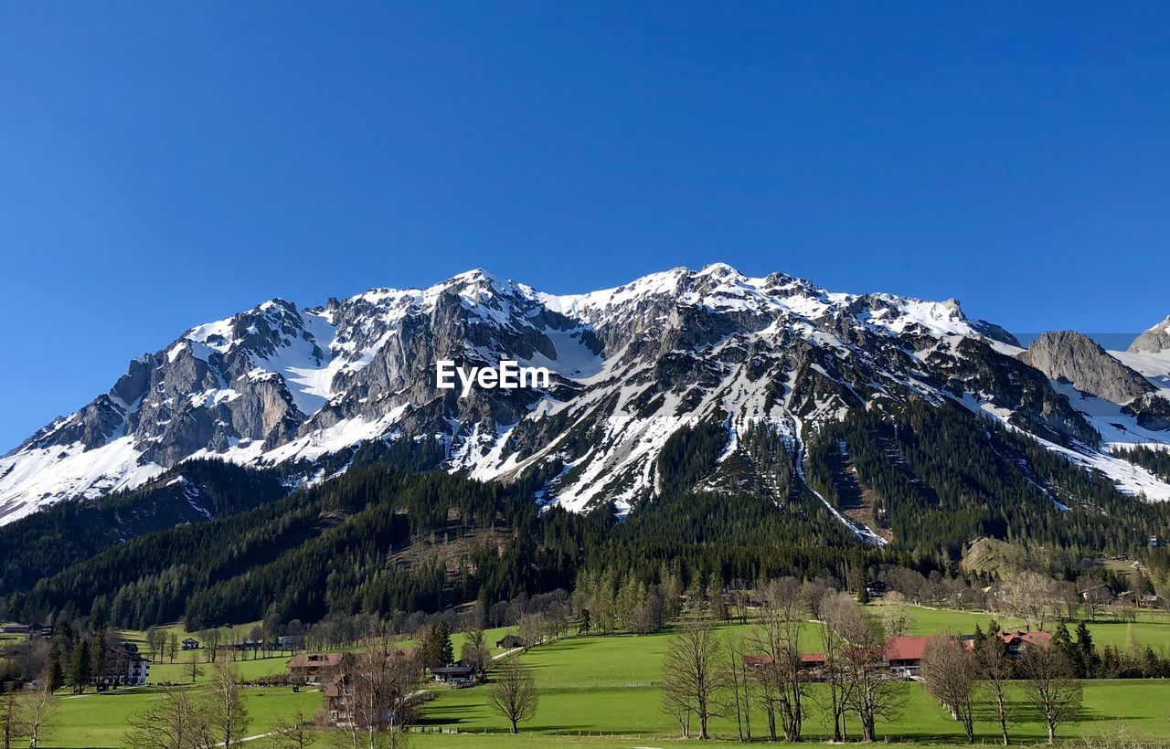 Scenic view of snowcapped mountains against clear blue sky