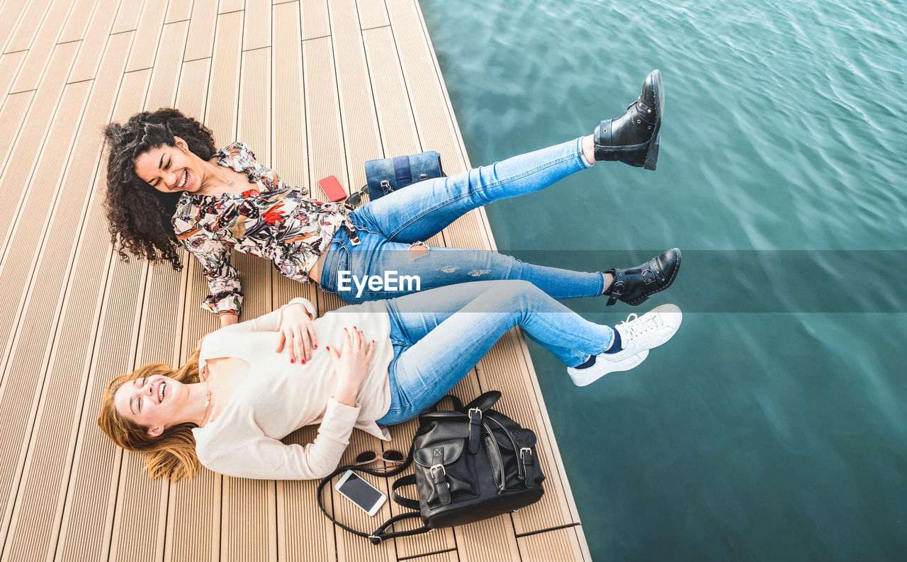 High angle view of female friends on pier over sea