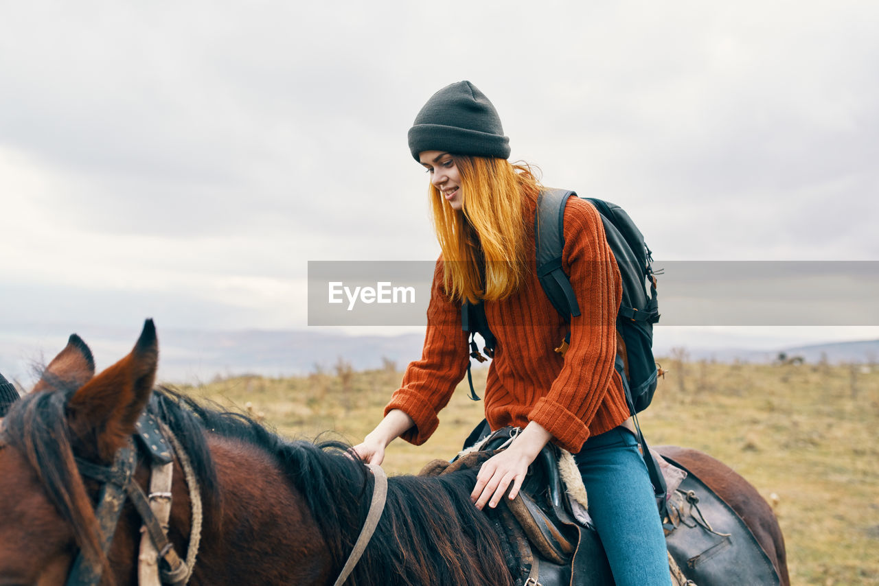 VIEW OF A YOUNG WOMAN RIDING HORSE