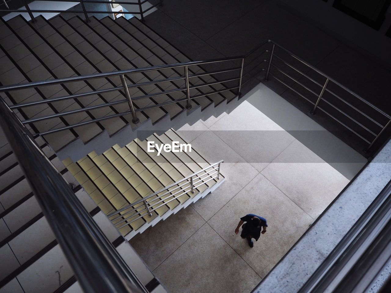 High angle view of person walking on staircase in building