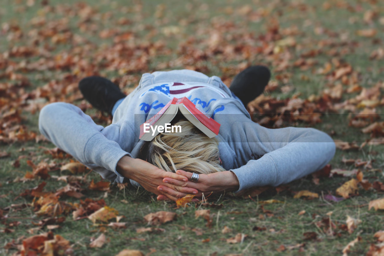 Mature woman lying down on field during autumn