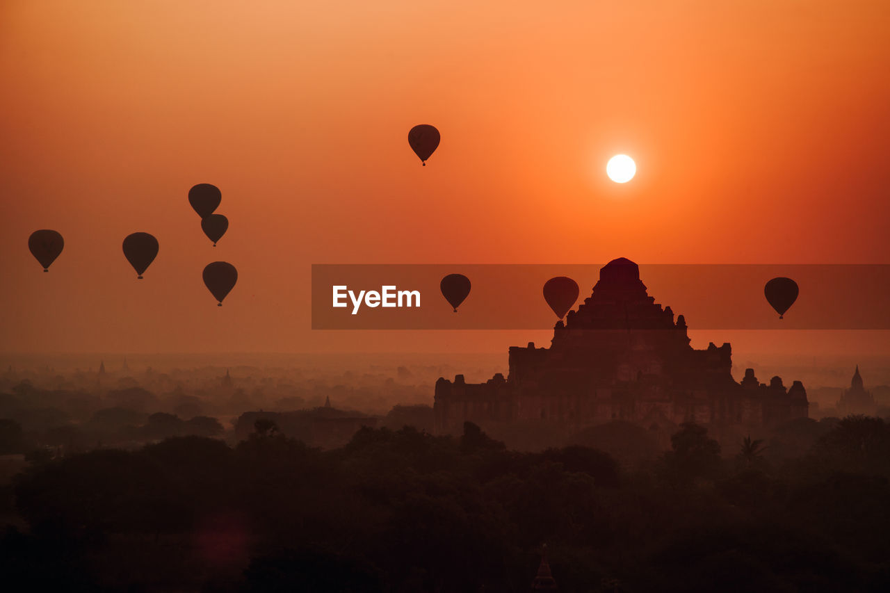 SILHOUETTE OF HOT AIR BALLOONS AGAINST SKY AT SUNSET