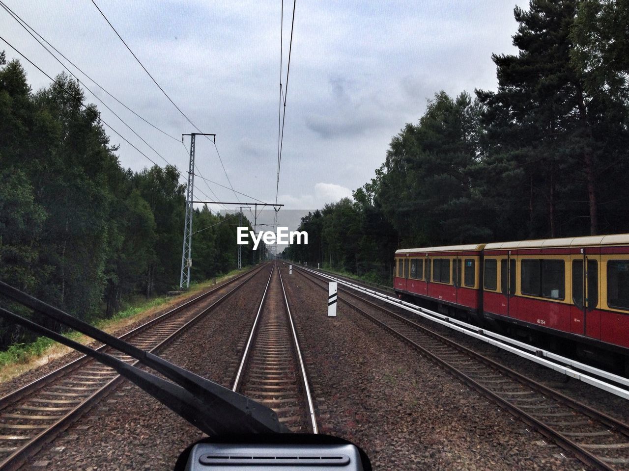 Train on railroad track against cloudy sky