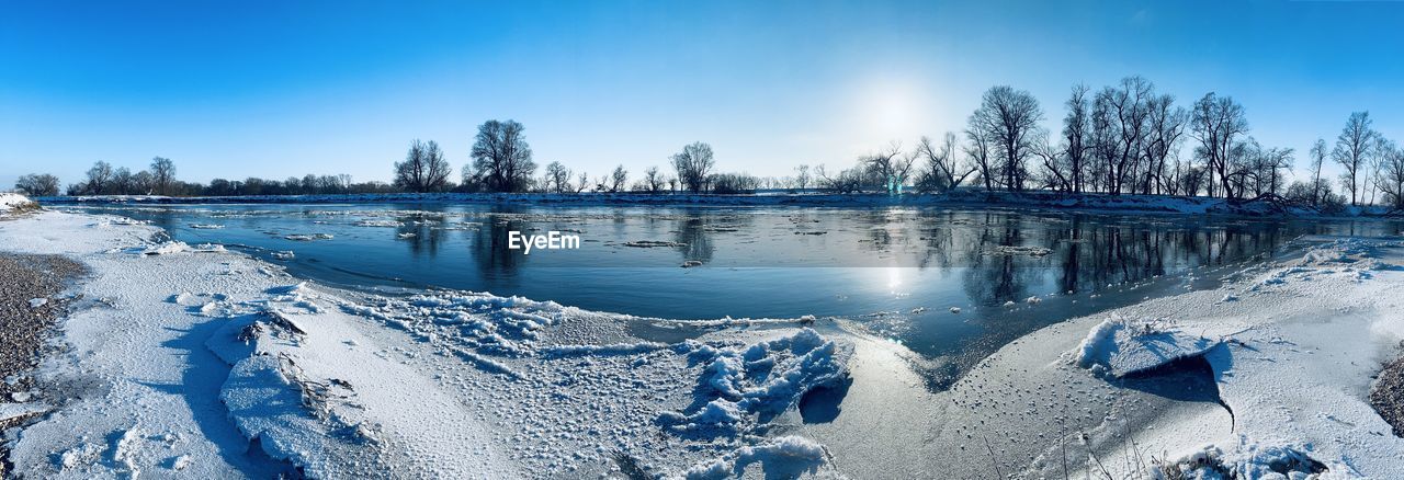SCENIC VIEW OF FROZEN LAKE AGAINST SKY