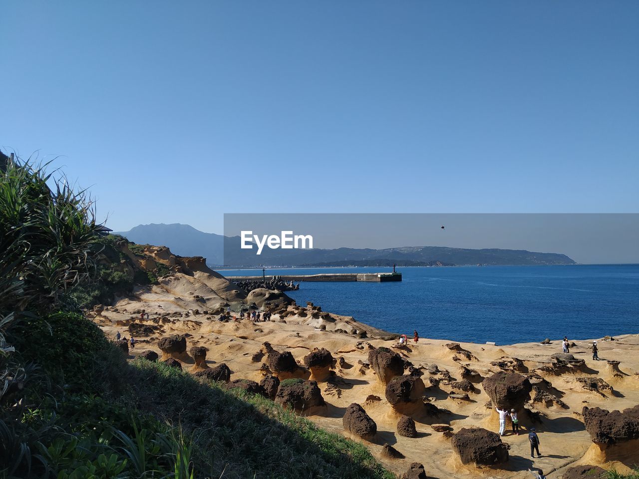 Scenic view of beach against clear blue sky