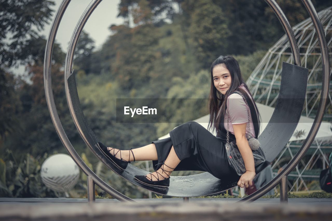 Portrait of smiling young woman sitting outdoors