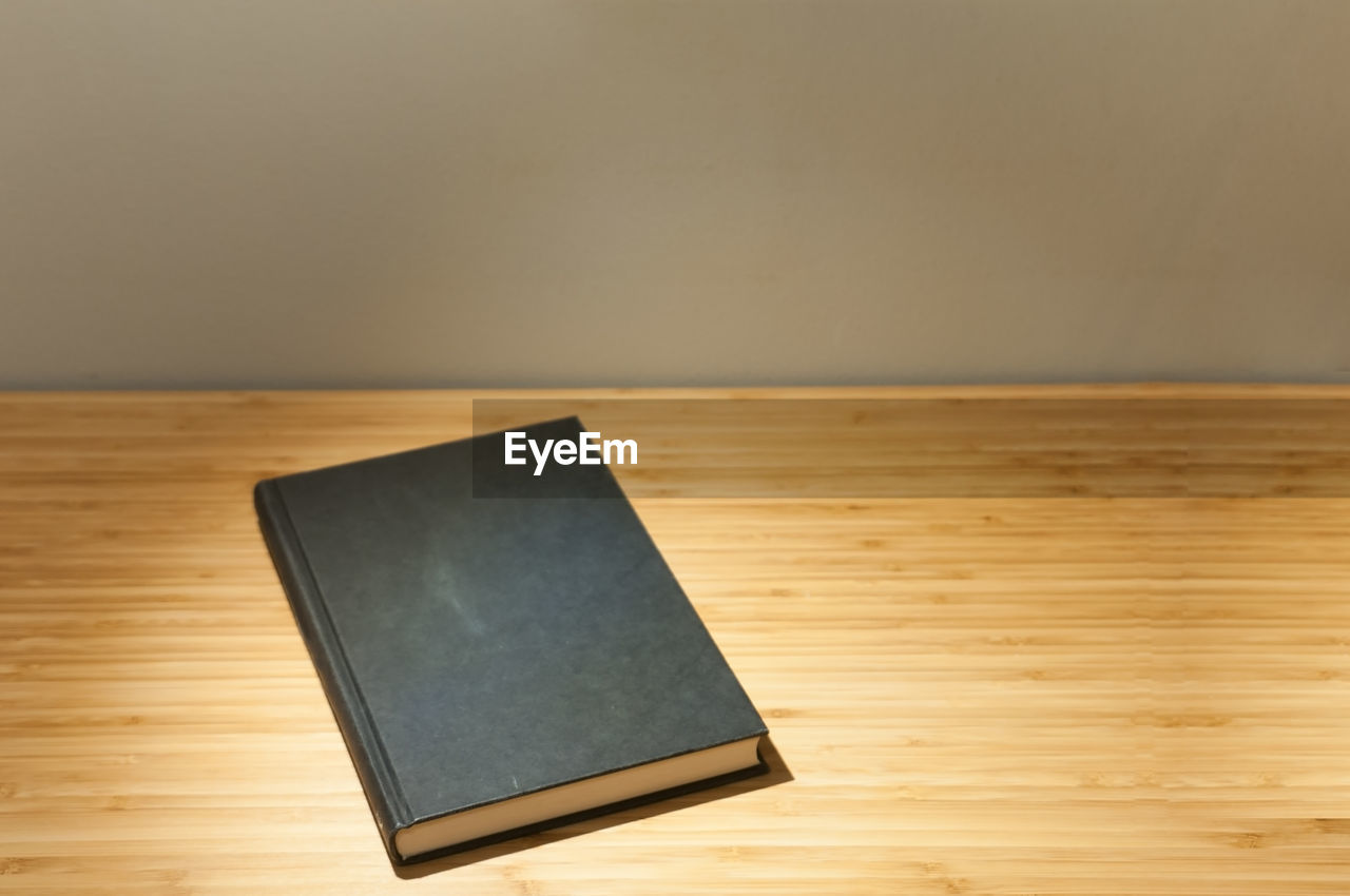 CLOSE-UP OF BOOK ON TABLE