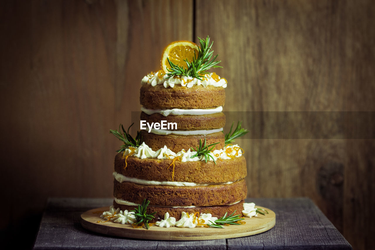 Cake on wooden table against wall