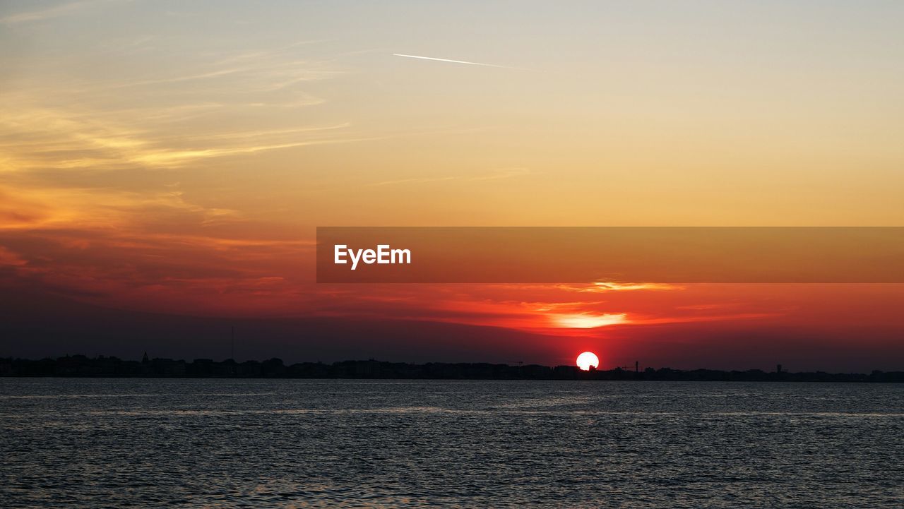 SCENIC VIEW OF SUNSET OVER SEA