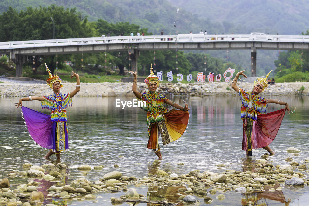 BOATS IN RIVER AGAINST BUILT STRUCTURES