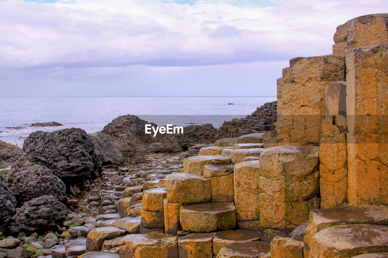 Scenic view of sea against sky and basaltic volcanic rocks at giant's causeway, northern ireland